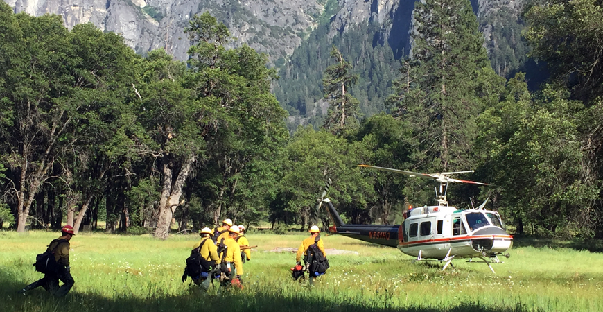 Firefighters working Yosemite National Park and boarding helicopter.